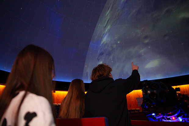 Besucherinnen und Besucher im Kuppelsaal des Planetariums