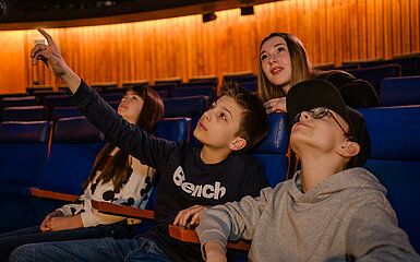 Kinder schauen auf die Kuppel im Planetarium