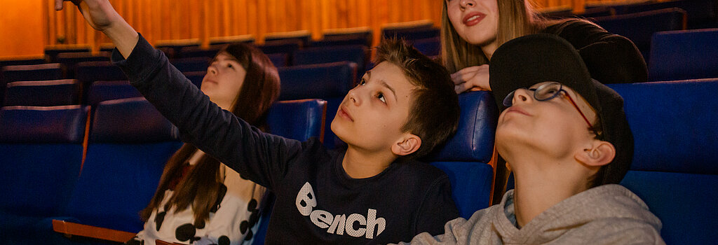 Kinder schauen auf die Kuppel im Planetarium